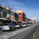 Photo of Brunswick Street, Fitzroy, in Victoria, in the middle of a busy day.