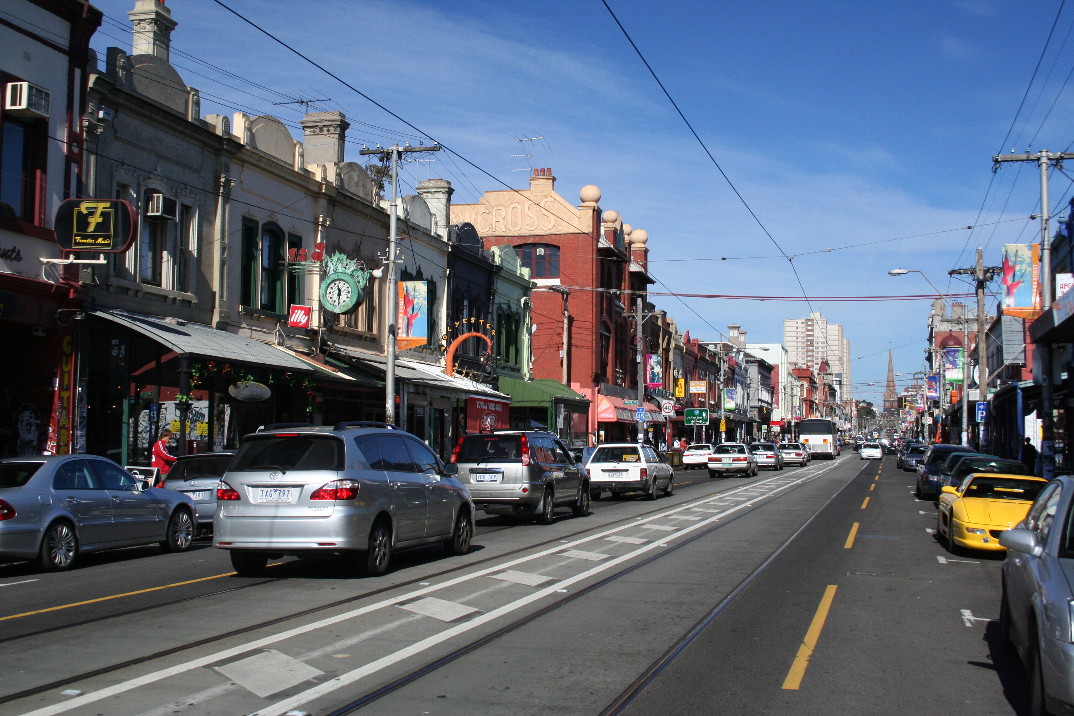 Photo of Brunswick Street, Fitzroy, in Victoria, in the middle of a busy day.