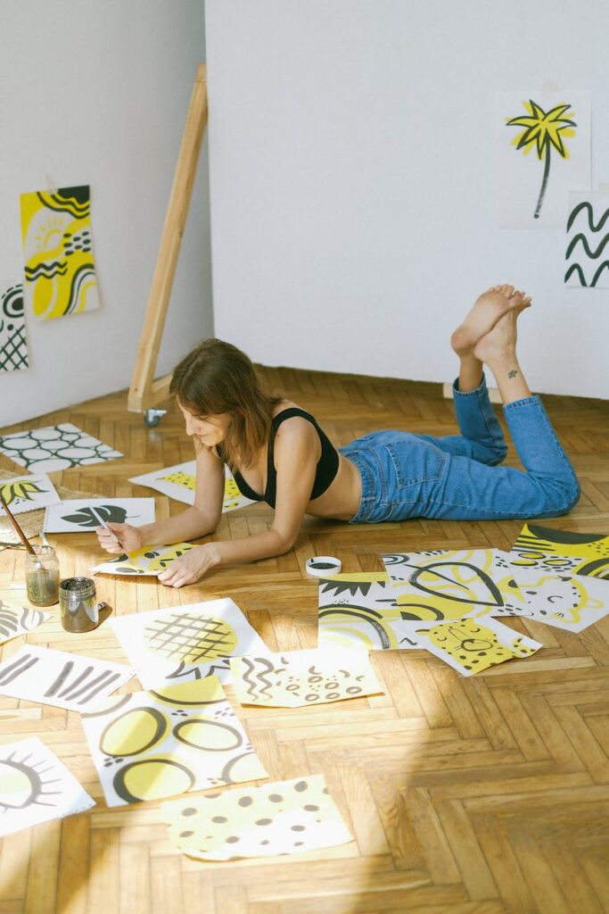 woman lying on floor while painting